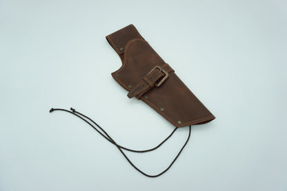wide view of kolser colt revolver leather right hand holster with brass buckle, loop for belt, and ties for let. 