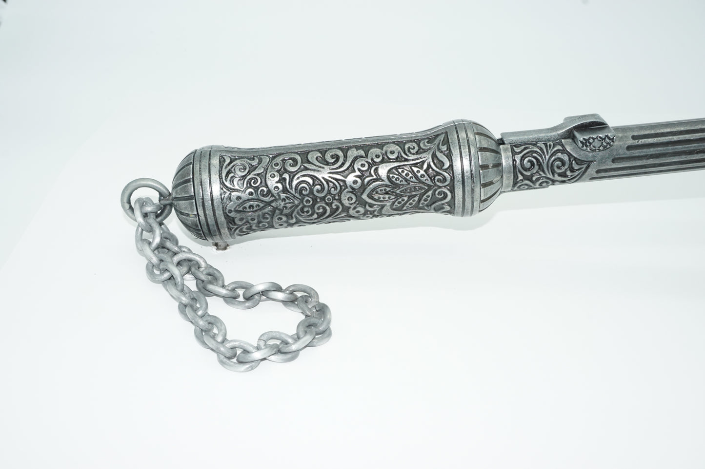 Butt end of ottoman pistol axe with intricate carvings and a chain to carry it.