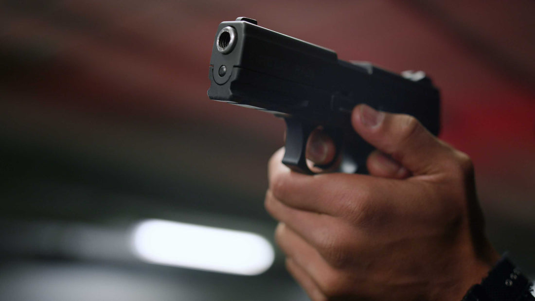 Replica Thompson submachine gun with wooden stock and drum magazine displayed on a wooden floor.