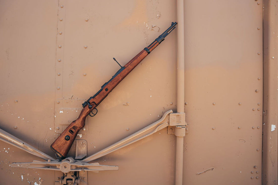 Right side of british enfield rifle leaning on a metal wall. 