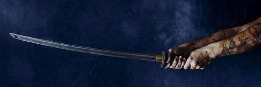 hands holding a katana sword on a midnight blue background. 