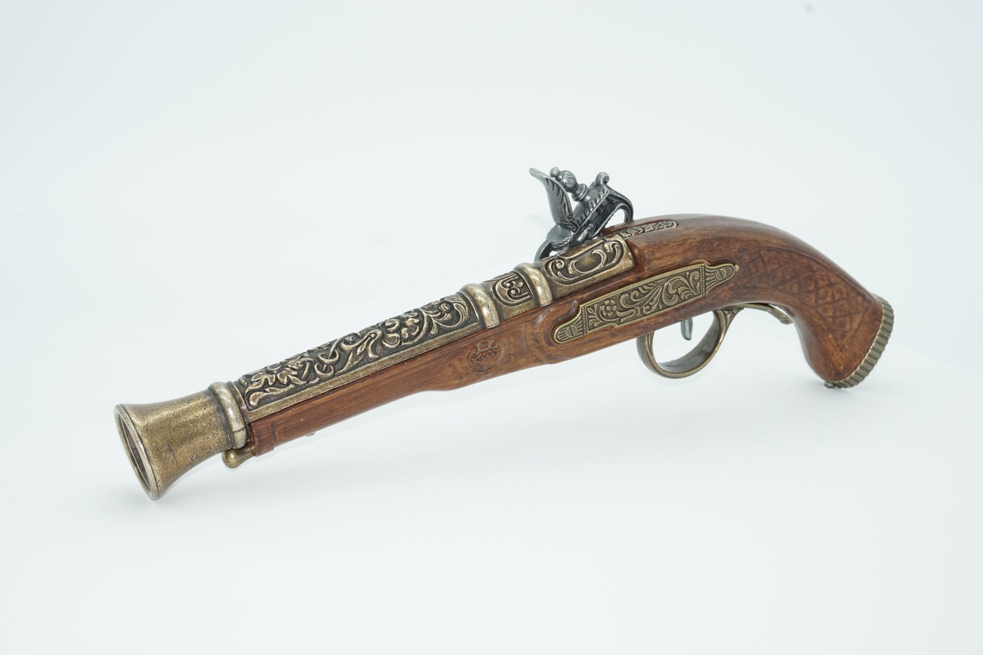Left side view of dueling pistol with brass barrel and silver firing pin. This pistol comes in a set of two and a cardboard decorative display box not shown.