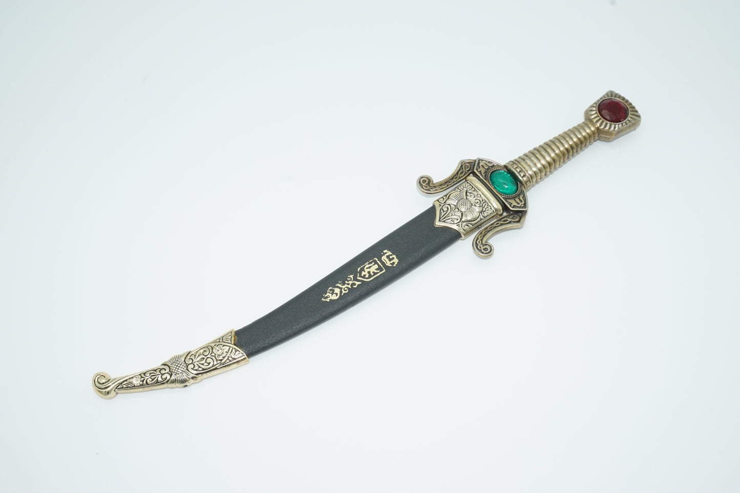 Top view of seville dagger sheathed in black sheath with decorative metal ends.