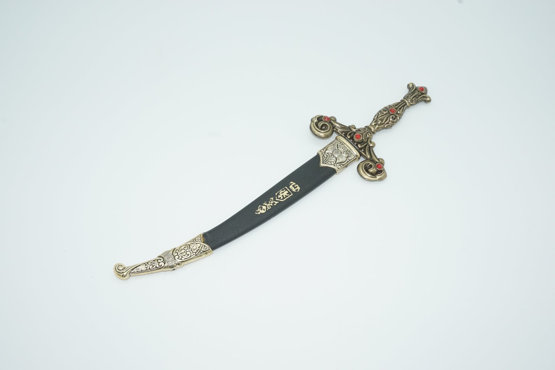 Spanish dagger in black sheath with silver accents on top, middle and bottom of the sheath. 