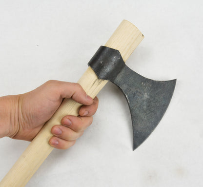 a hand holding the wooden handle of the viking throwing axe